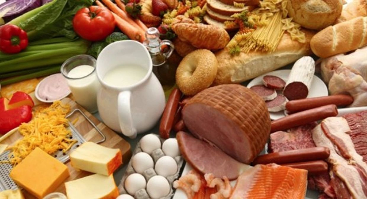 Wide array of foods containing L-Carnitine, including milk, ham, eggs, cheese, salami, bread rolls.