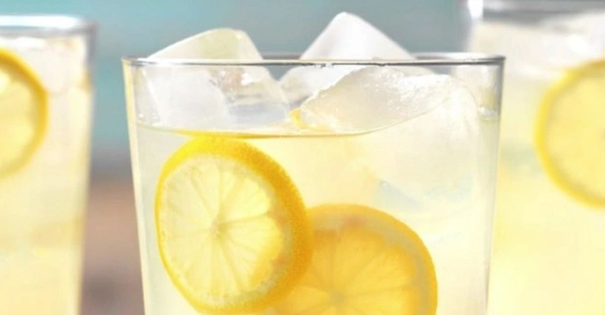 A drink containing a lemon slice and ice, the peel of the lemon rich in Limonene, dietary antiviral.