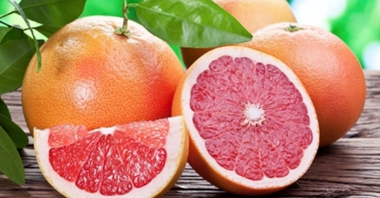 Whole and sliced grapefruits, one fruit that is high in Naringenin content, a potent flavonoid.