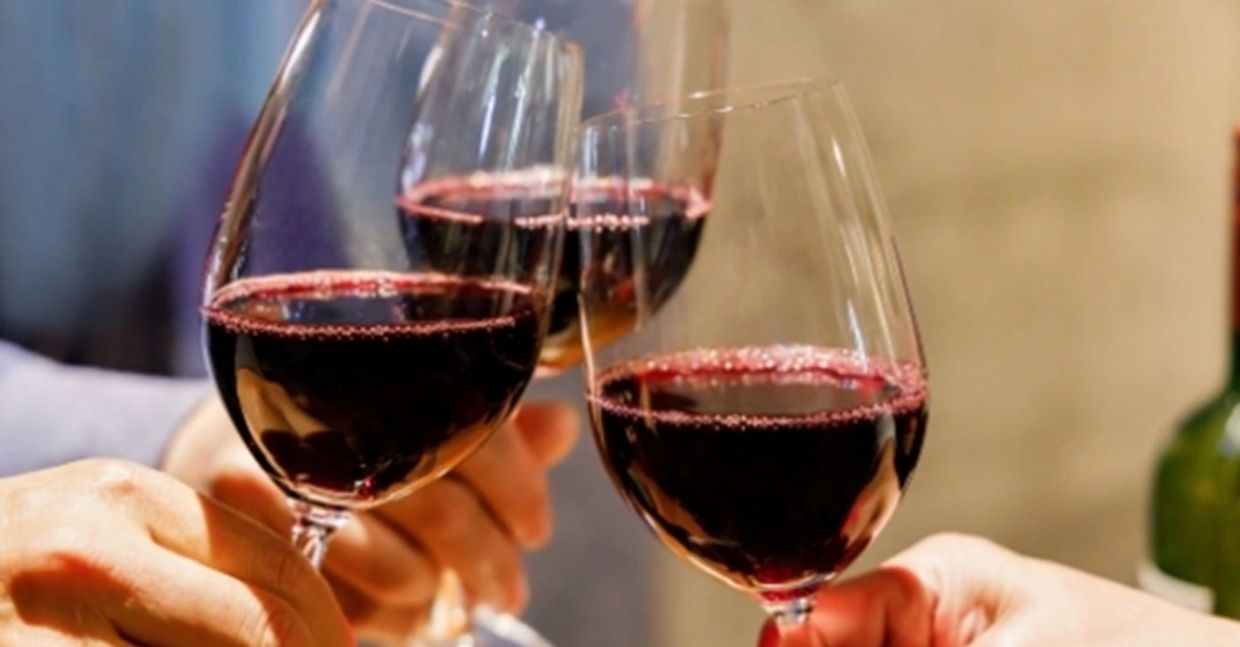 Glasses of red wine being toasted, a drink which - like grape juice - contains antiviral Resveratrol