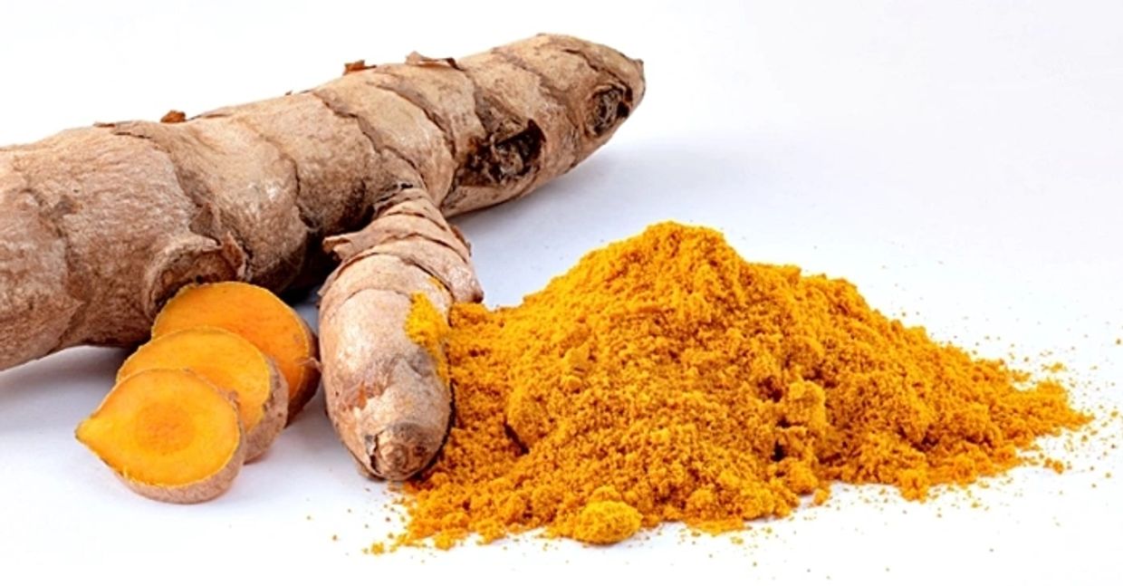 A piece of Turmeric root, some sliced, some powdered, which contains antiviral ingredient Curcumin.