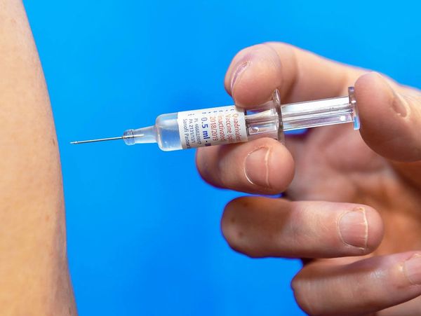 Vaccine dose against a viral illness, just about to be administered via needle into somebody's arm.