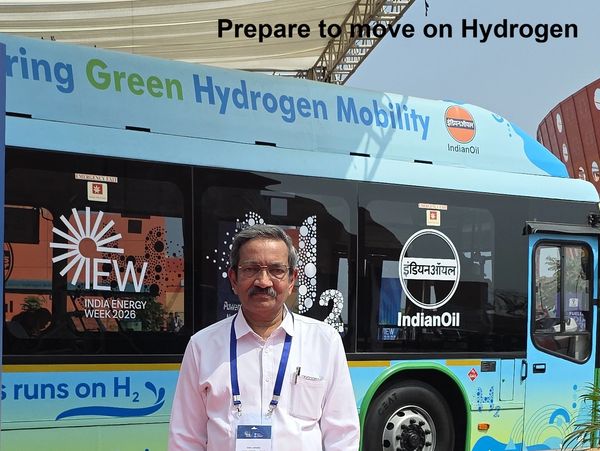 Man standing in front of a green hydrogen mobility bus promoting clean energy.