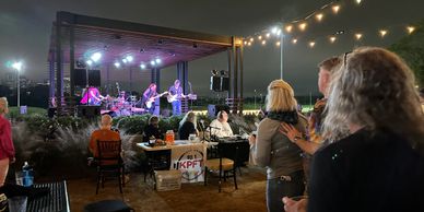 Outdoor nighttime concert with a live band and an audience.