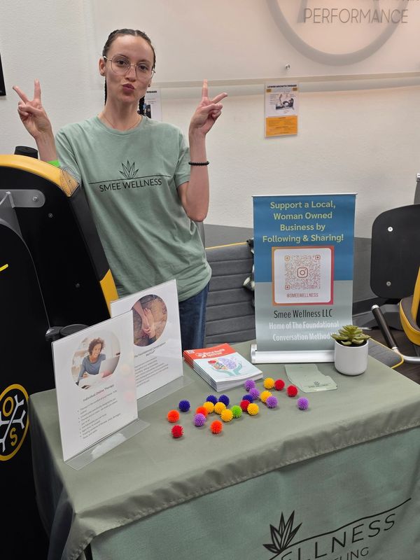 A woman at a wellness booth promoting Smee Wellness and concierge counseling.