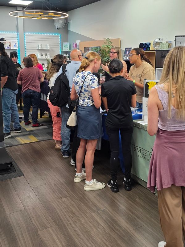 People socializing and exploring booths at an indoor event or expo.