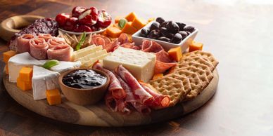 Charcuterie board with meats, cheeses, and crackers.