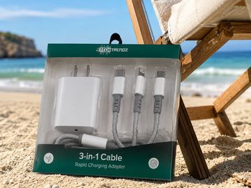 3-in-1 rapid charging adapter set on a sandy beach near a wooden chair.