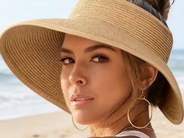 Young woman wearing a wide-brimmed sun hat at the beach.