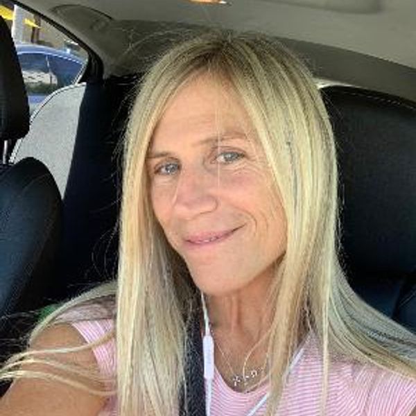 Smiling woman with blonde hair in a car.