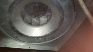 Close-up of a large industrial fan inside a metal casing.
