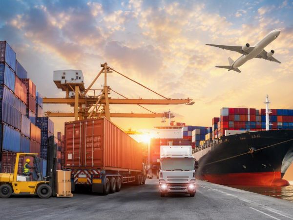 Busy shipping port with containers, trucks, and an airplane.