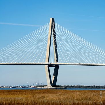A cable-stayed bridge with a clear blue sky and water below.