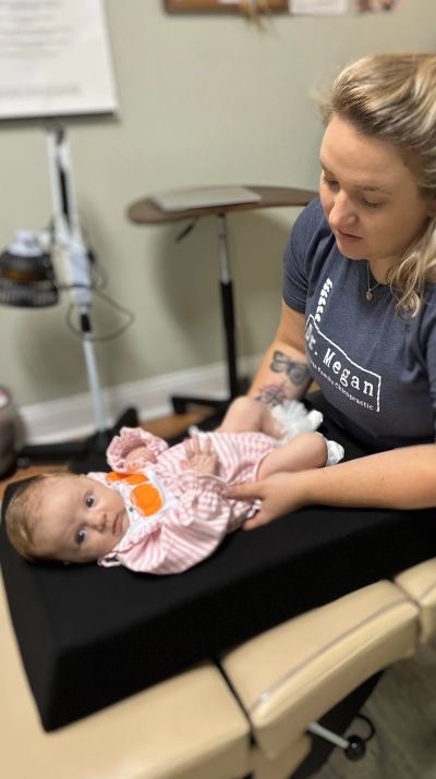 Woman tending to a baby on a medical table.