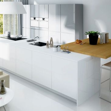 Modern white kitchen with wooden breakfast bar and large window.
