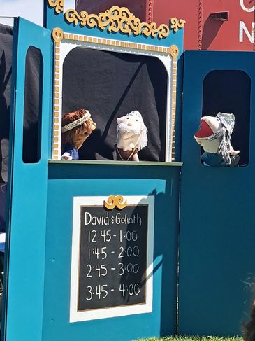 Puppet show of David and Goliath outdoors.