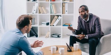 Two men engaged in a serious conversation in a modern office setting.