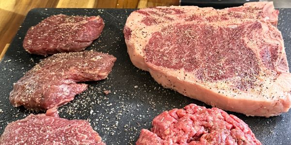 Various cuts of raw beef seasoned with salt and pepper.