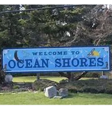 Welcome sign for Ocean Shores with a beach-themed design.