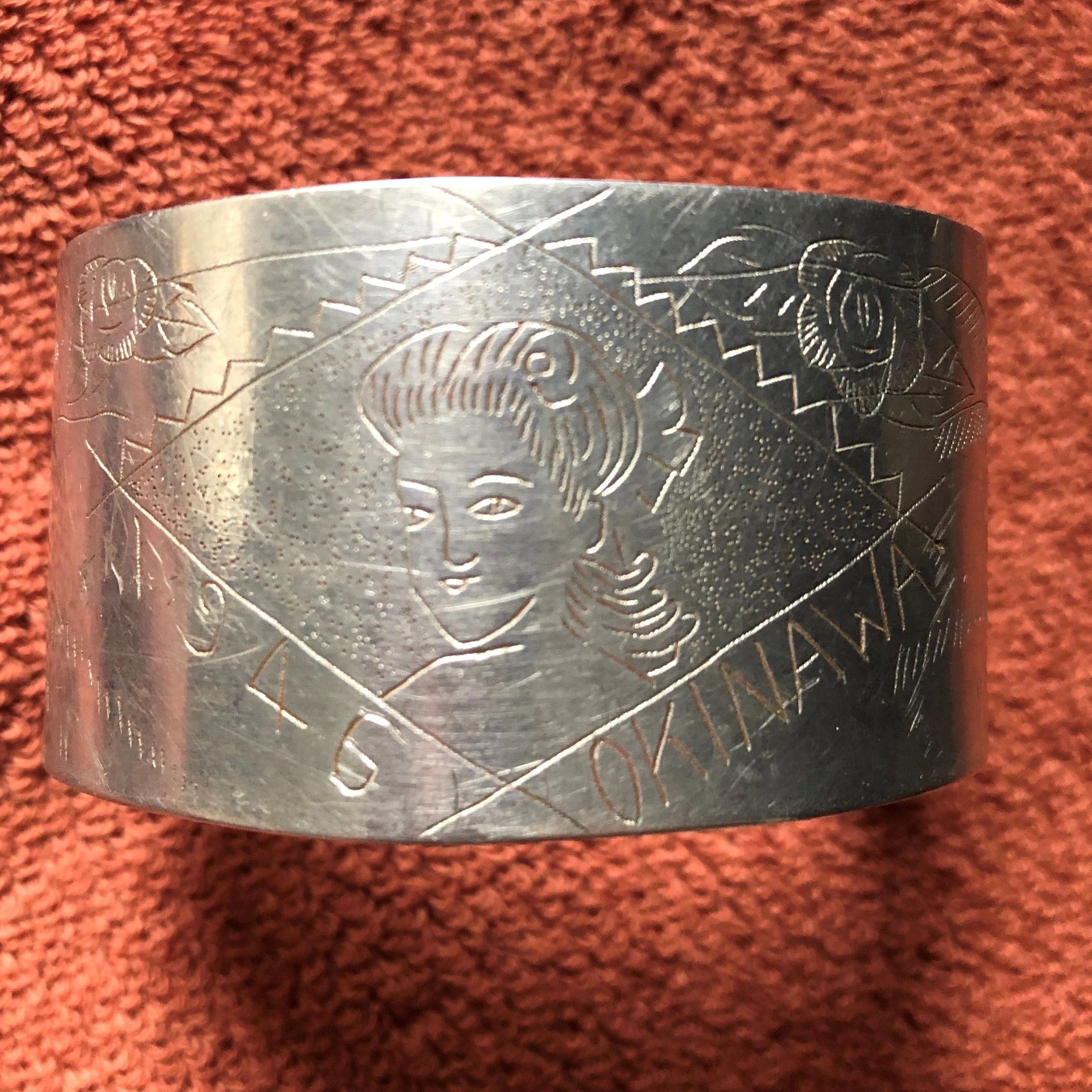 A cuff bracelet made of aluminum from a downed Japanese plane, crafted by an Okinawan.