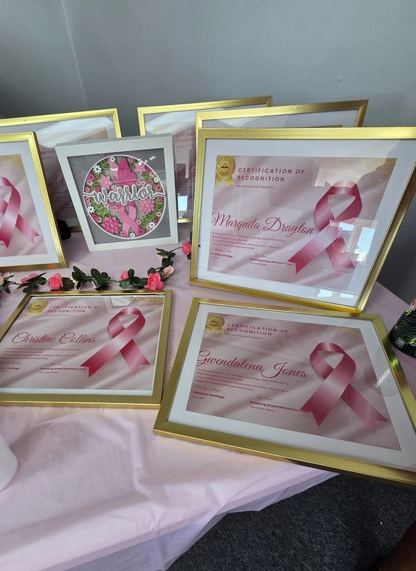 Framed breast cancer awareness certificates and decorations.
