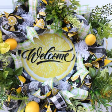 Lemon welcome wreath hanging on white door. 