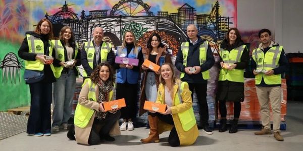 group of happy workers in the warehouse with boxes to distribute