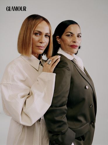 Two stylish women pose confidently for Glamour magazine.