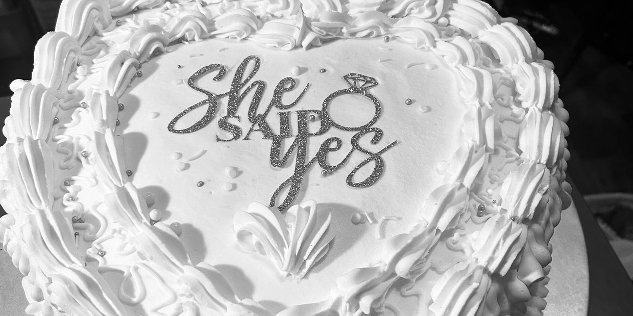 Heart-shaped engagement cake with the words "She said yes."