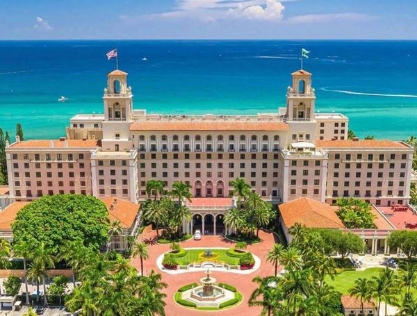 Historic oceanfront hotel with lush gardens and turquoise waters.