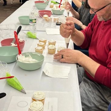 Students learning how to create frosting designs on cupcakes. Lots of laughter and fun!