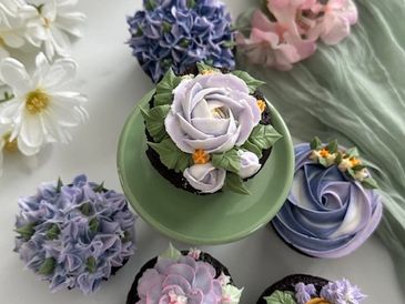 Lavendar flowers made with buttercream frosting arranged near real flowers.