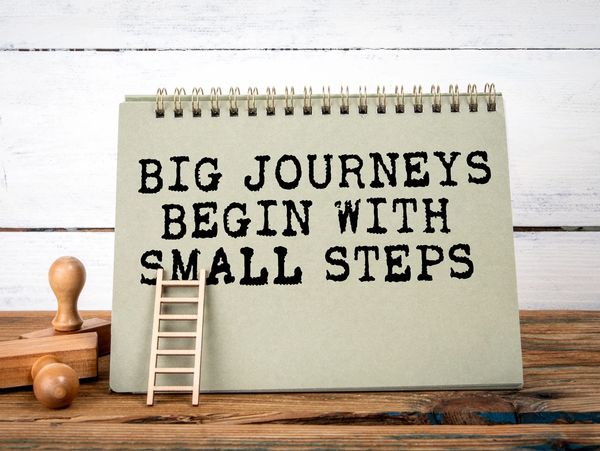 Inspirational quote about journeys and small steps on a desk calendar.