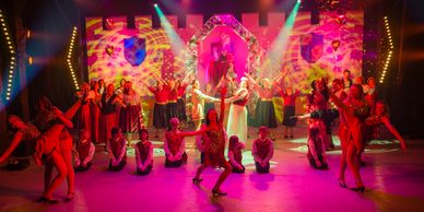 Colorful stage performance with dancers and vibrant lighting effects.