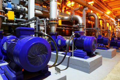 Row of industrial blue motors in a factory setting.