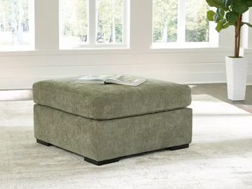 Green cushioned ottoman in a bright room.