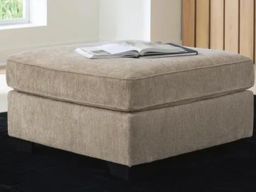 Beige cushioned ottoman with a book on top.