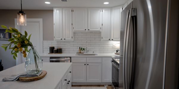 Modern white kitchen with stainless steel appliances.