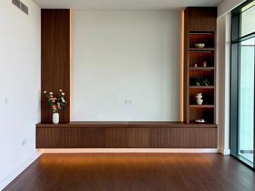Modern living room with wooden shelves and a large window.