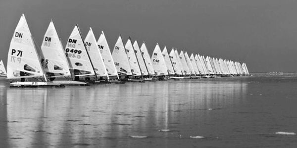 Line of ice sailboats on frozen ice at the start of a race.