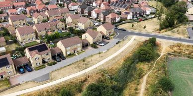Aerial view of a suburban neighborhood with houses and greenery.