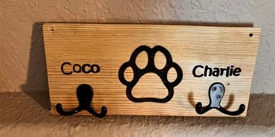 Personalized wooden leash holder with custom name and paw print. 