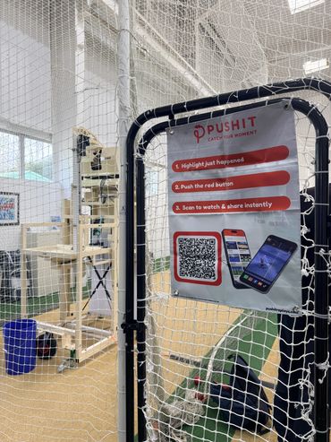 A netted sports area with a sign promoting the PushIt app for instant video highlights.