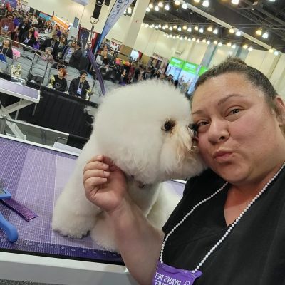 Woman and fluffy dog at a pet event.