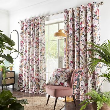 Made to measure eyelet floral curtains on a silver curtain rail with matching upholstery cushions