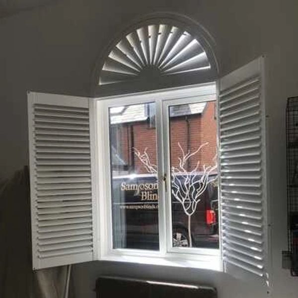 White window shutters, including a semi circle shutter with Sampson Blinds van in background