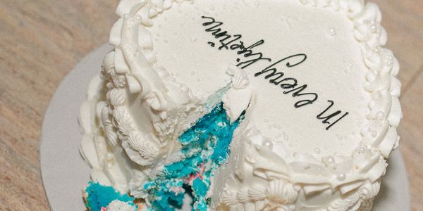 White cream cake with blue interior and 'In every life...' text.