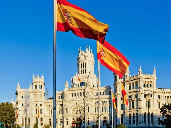 Na Espanha prédio histórico com bandeira espanhola.
