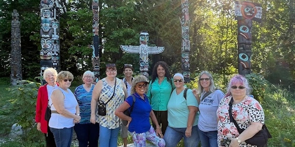 A group of people standing in front of a forest.