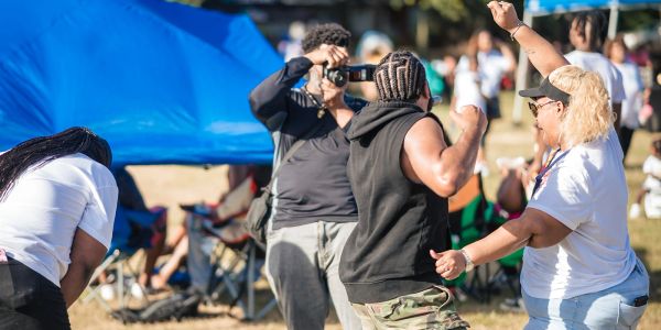 People enjoying an outdoor event with dancing and photography.